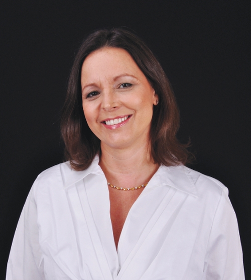 Portrait of a smiling woman in a white blouse on a black background